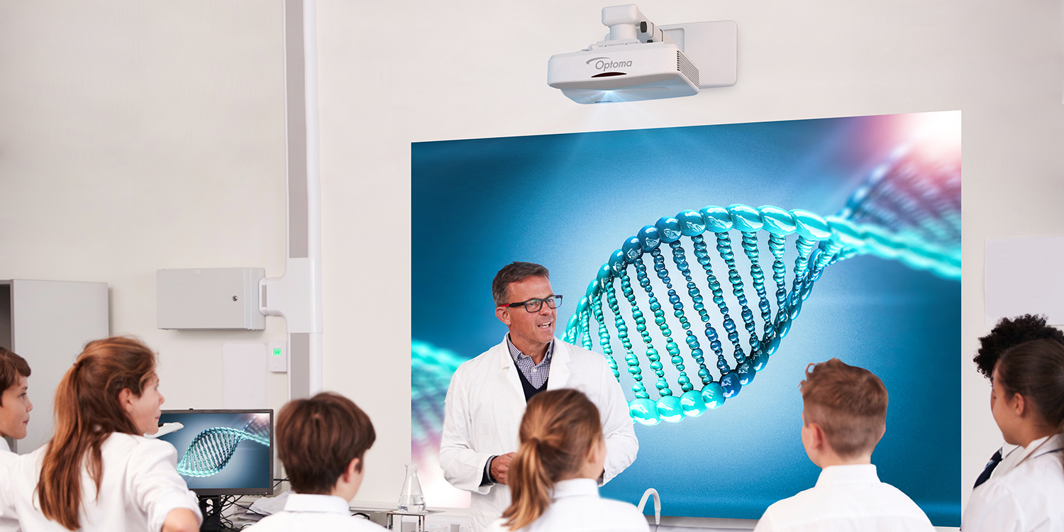 Science teacher projecting an image of DNA using a short throw projector for students to see.